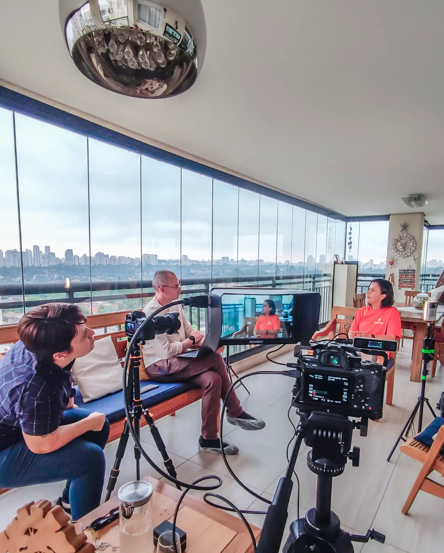 Equipe de gravação captando imagem de duas pessoas conversando.